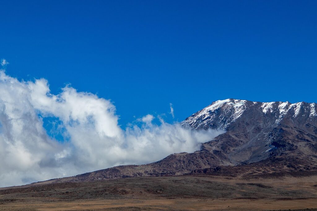 Kilimanjaro zirvesine yaklaşan yürüyüşçüler ve bulutlu gökyüzü