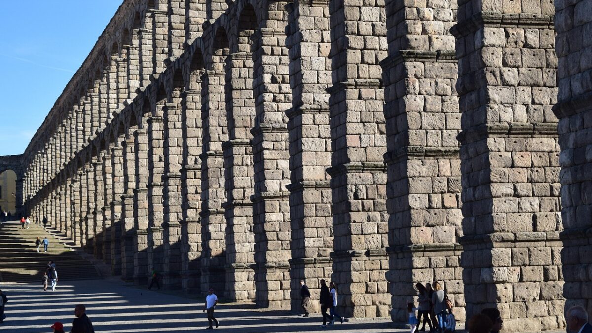 Segovia'daki Roma dönemi antik su kemeri, taş kemerleri ve gün ışığında uzanan yapısıyla