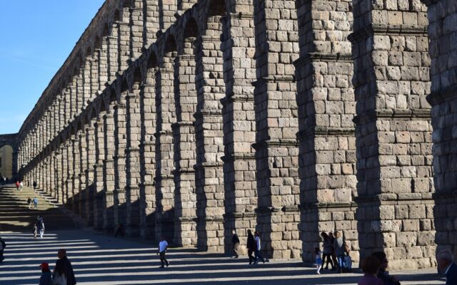Segovia'daki Roma dönemi antik su kemeri, taş kemerleri ve gün ışığında uzanan yapısıyla
