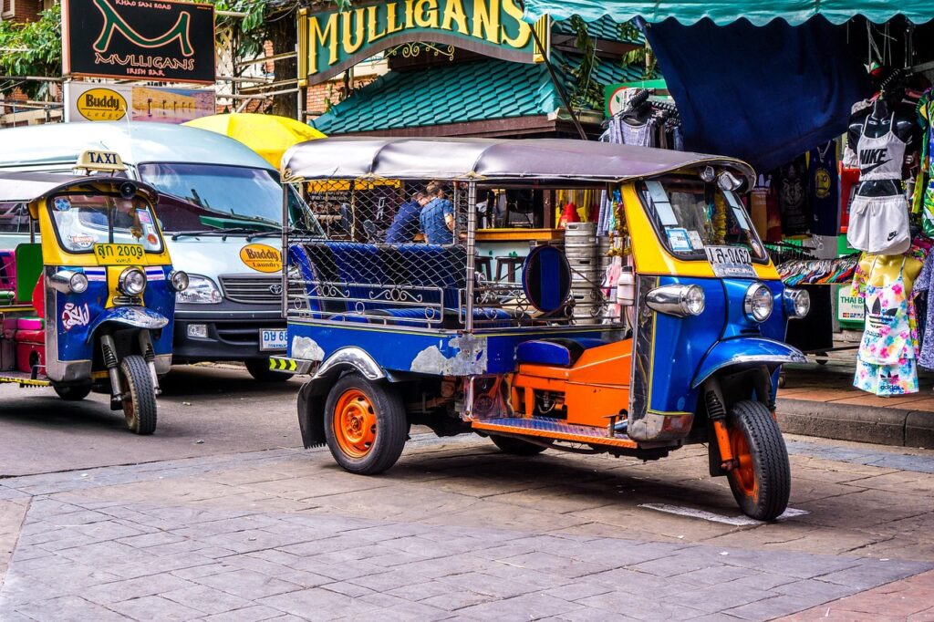 Asya'nın bir şehrinde tuk-tuk ve taksi trafiği