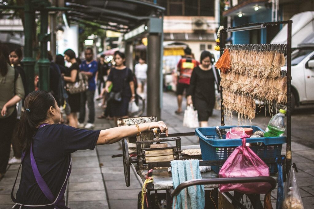 Bangkok'ta bir tezgâhçının önünde wok içinde yemek pişirmesi