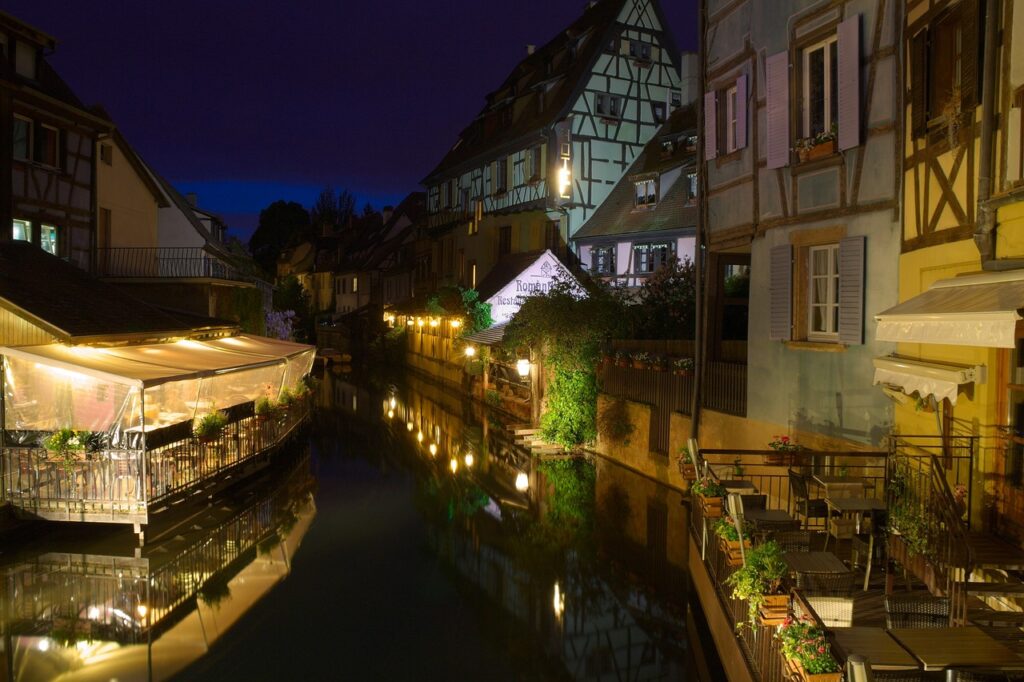 Colmar'ın Petite Venise semtinde kanal kenarındaki renkli ahşap evler