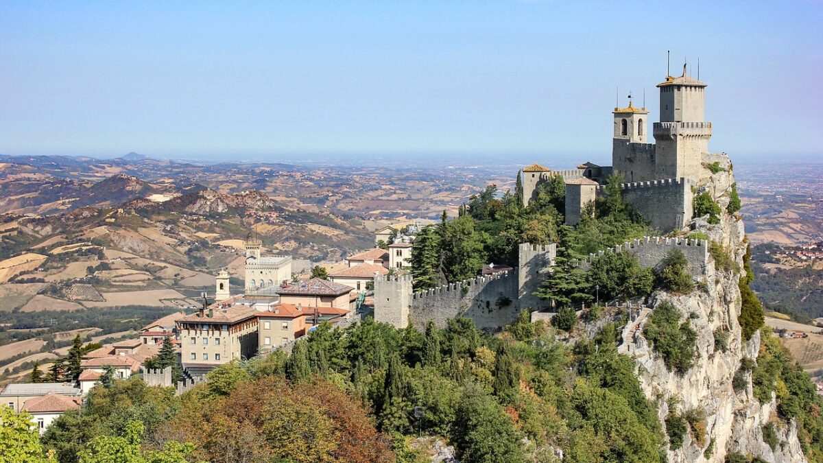 Monte Titano'nun zirvesindeki kuleler ve yeşil tepelerle çevrili San Marino manzarası