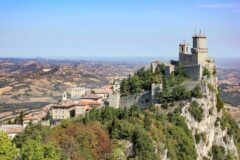 Monte Titano'nun zirvesindeki kuleler ve yeşil tepelerle çevrili San Marino manzarası