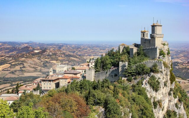 Monte Titano'nun zirvesindeki kuleler ve yeşil tepelerle çevrili San Marino manzarası