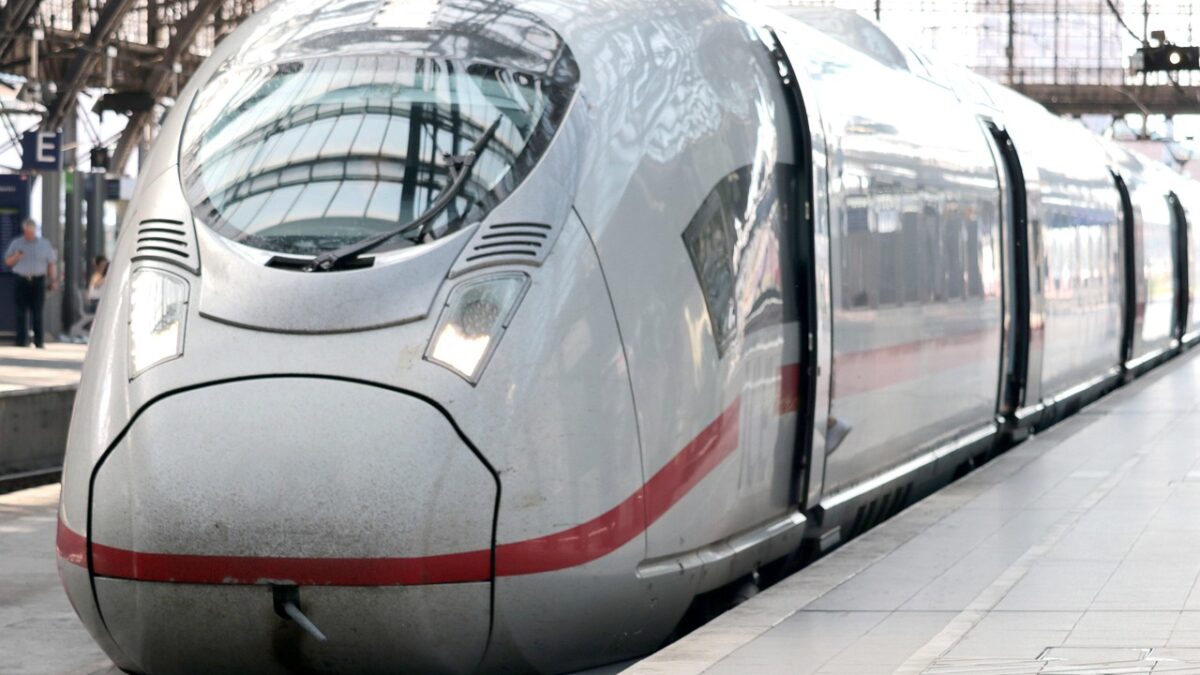 Avrupa'da raylar üzerinde ilerleyen modern bir yolcu treni ve arka planda kırsal manzara