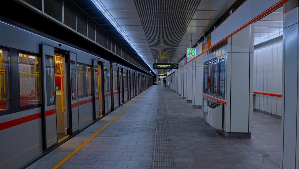 Viyana'da tarihî mimarili bir tren istasyonu ve peronda bekleyen yolcular