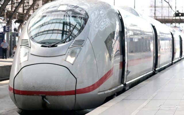 Avrupa'da raylar üzerinde ilerleyen modern bir yolcu treni ve arka planda kırsal manzara