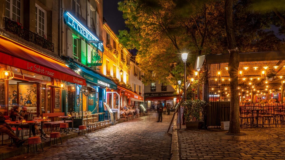 Avrupa'nın tarihi bir sokağında yürüyen gezginler ve taş binalar