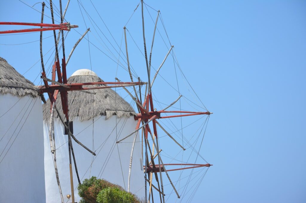 Mikonos adasında beyaz evlerin yanındaki yel değirmenleri