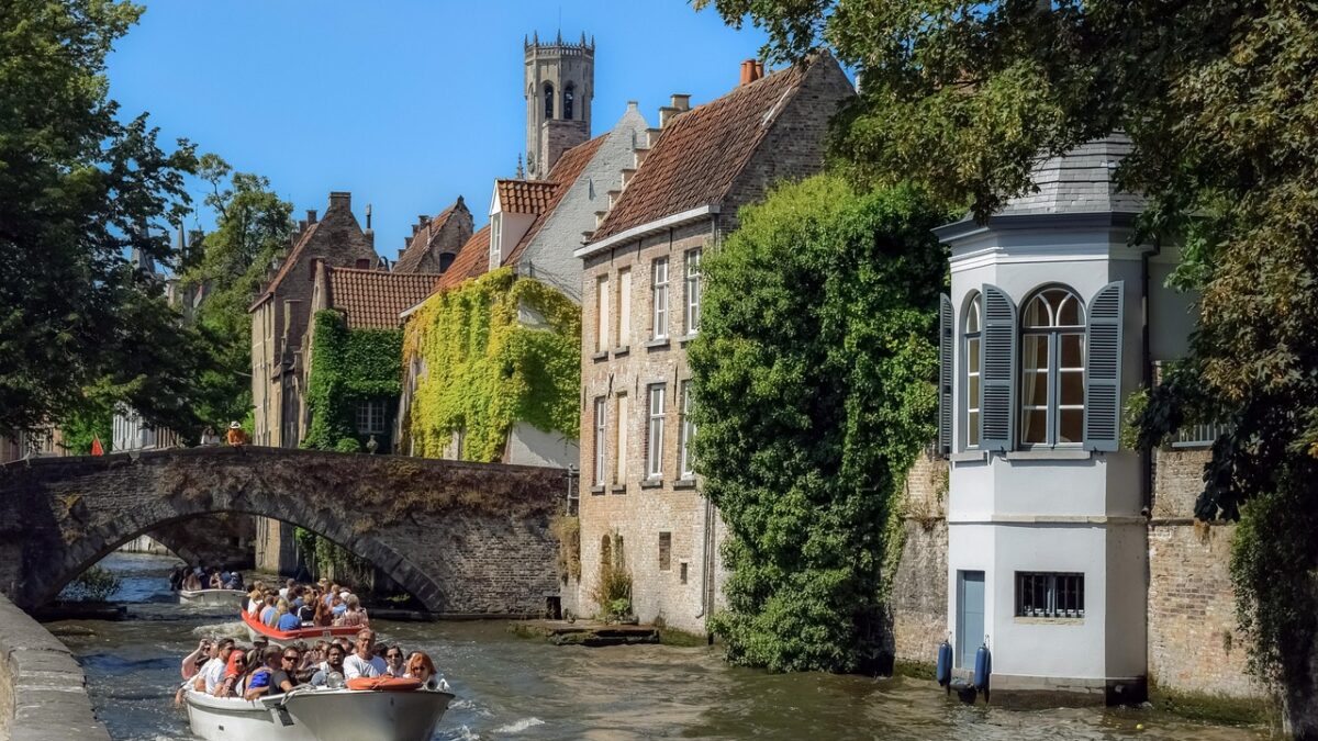 Brugge kanallarında tekneler ve kiremit çatılı ortaçağ evleri
