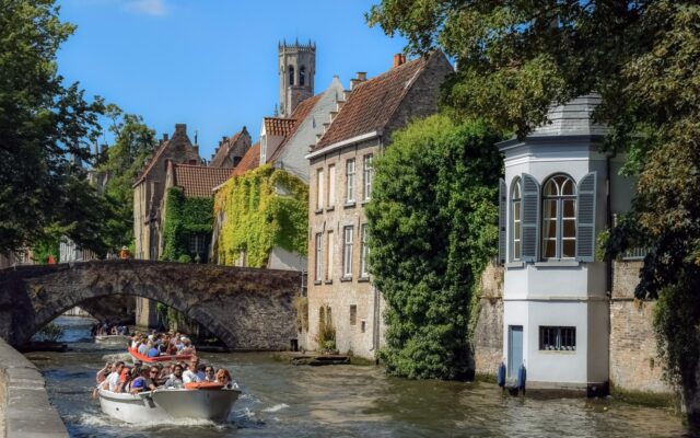Brugge kanallarında tekneler ve kiremit çatılı ortaçağ evleri