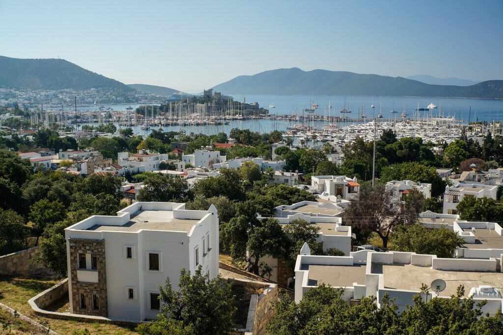 Bodrum marinasında demirli yatlar ve beyaz binalar, gece hayatının canlı olduğu yarımada manzarası