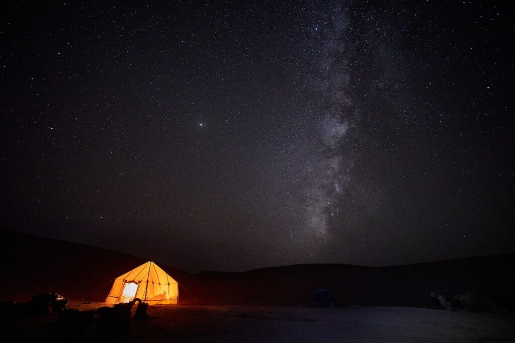 Gece çölde yıldızlı gökyüzü altında kamp alanı