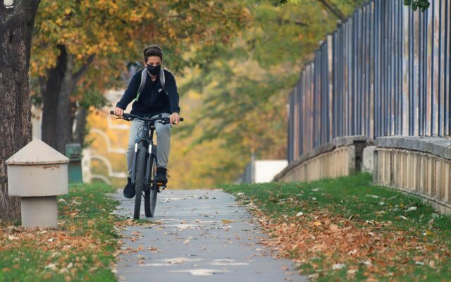 Nehir kenarındaki bisiklet yolunda pedal çeviren bir gezgin