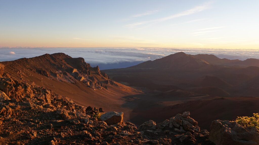 Haleakalā kraterinde gündoğumunda bulutlarla kaplı volkanik manzara