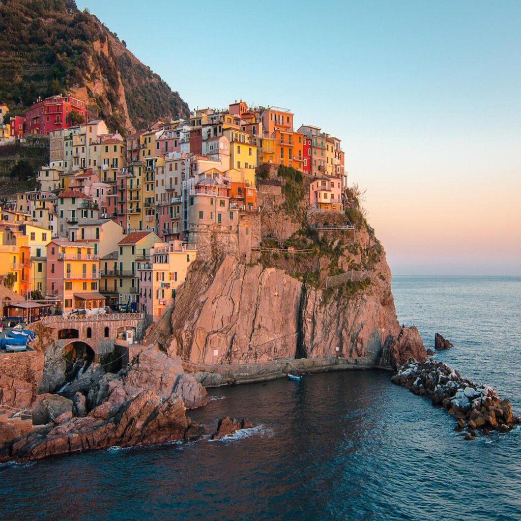 Cinque Terre kıyısında kayalıklara tutunmuş renkli evler ve gün batımı