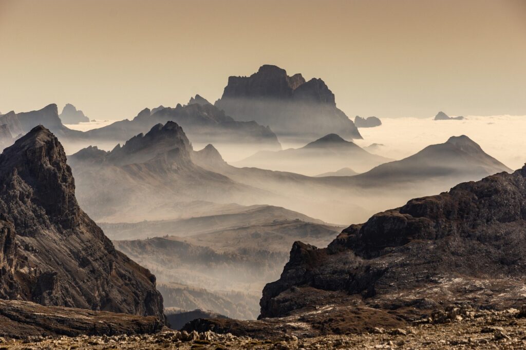 Dolomitler'de gün doğumunda kayalık kuleler ve vadi manzarası