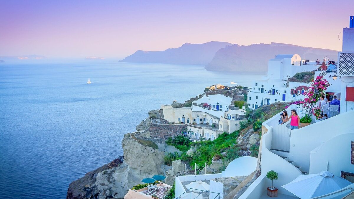 Gün batımında Santorini'nin beyaz evleri ve mavi kubbeleri