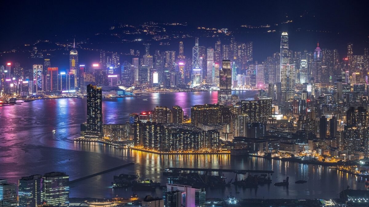 Hong Kong'da gece Victoria Limanı ve gökdelenlerin ışıklarıyla aydınlanmış şehir manzarası