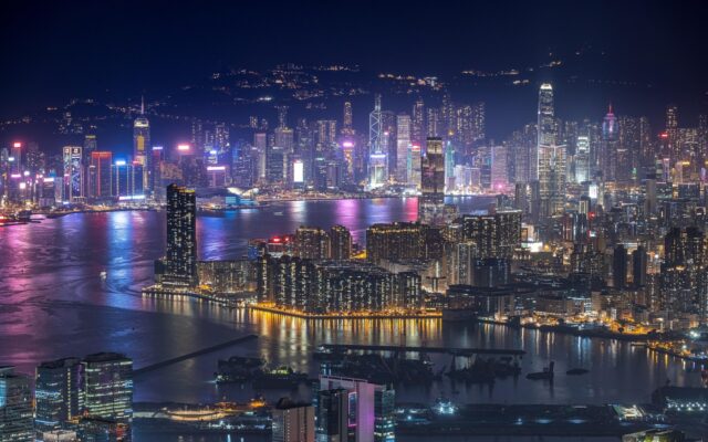 Hong Kong'da gece Victoria Limanı ve gökdelenlerin ışıklarıyla aydınlanmış şehir manzarası