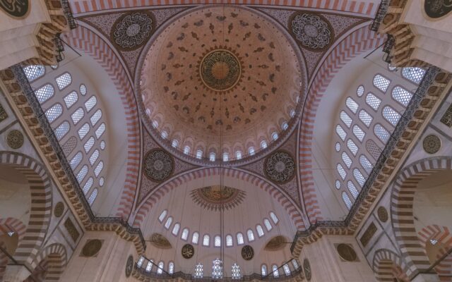 İstanbul'da Boğaz kıyısında gün batımında bir vapur ve tarihi yarımada silueti