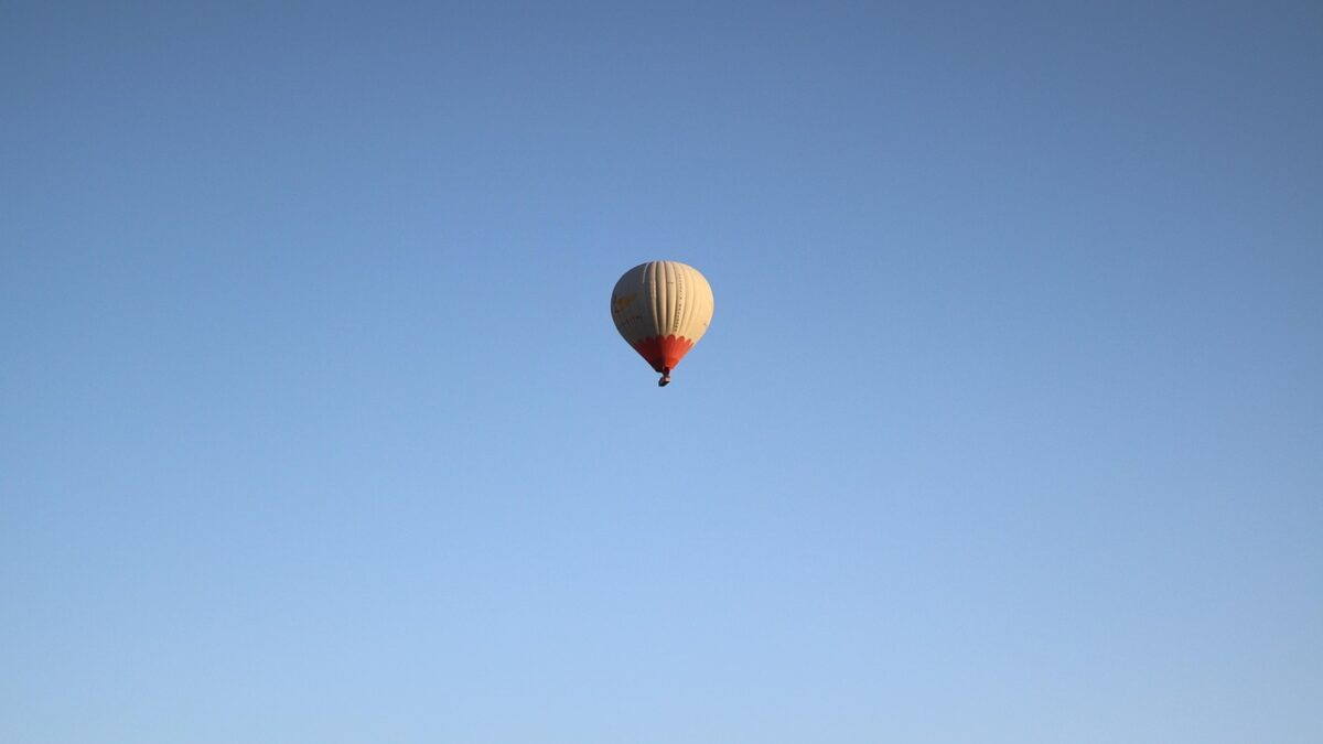 Kapadokya'da gün doğumunda peri bacaları üzerinde süzülen sıcak hava balonları