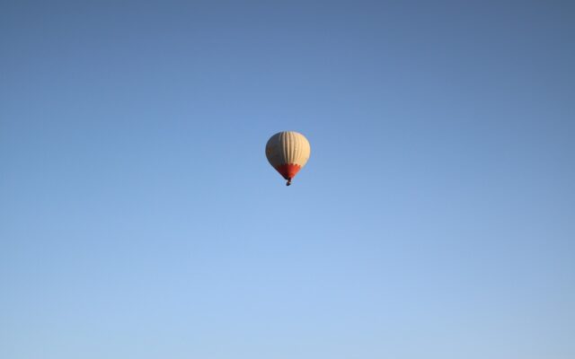Kapadokya'da gün doğumunda peri bacaları üzerinde süzülen sıcak hava balonları