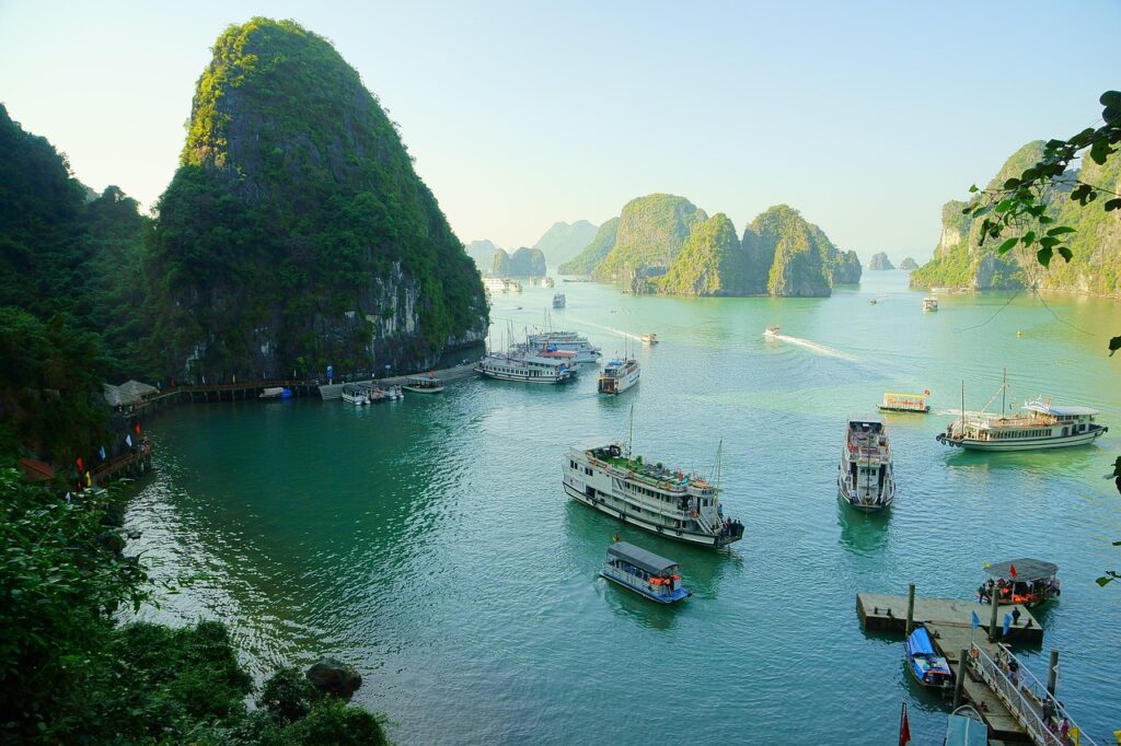 Kuzey Vietnam'da Ha Long Körfezi'nde tekneler ve kireçtaşı adacıklar