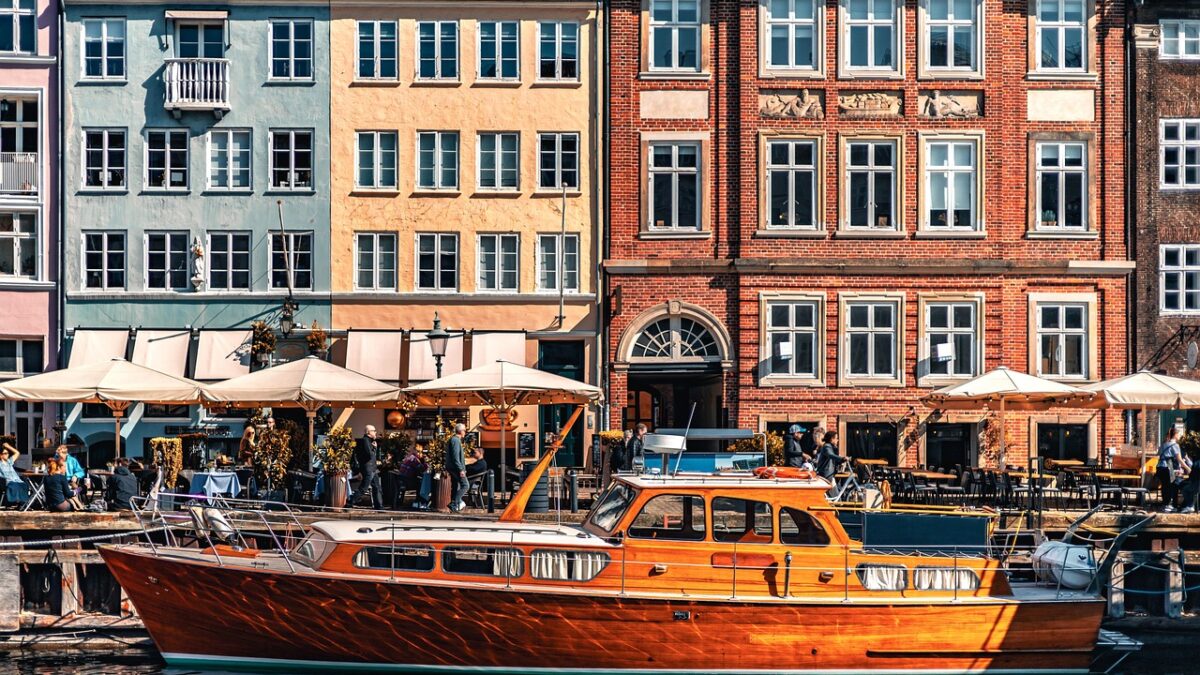 Kopenhag'da Nyhavn kanalı boyunca renkli eski liman evleri ve tekneler