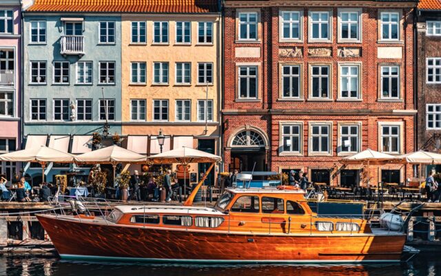 Kopenhag'da Nyhavn kanalı boyunca renkli eski liman evleri ve tekneler