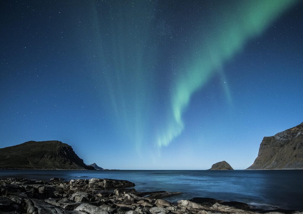 Norveç fiyordunun üzerinde gökyüzünde dalgalanan kuzey ışıkları