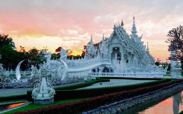 Chiang Rai'deki Beyaz Tapınak'ın gün ışığında görünümü ve çevresindeki ağaçlar