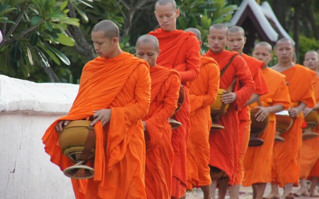 Laos'ta gezilecek yerler arasında yer alan Luang Prabang'da sabah sisi içinde tapınak ve nehir manzarası