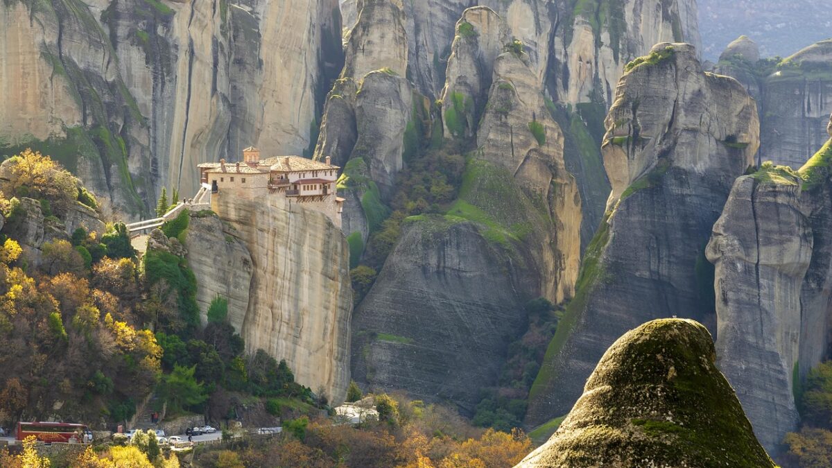 Yunanistan'ın Meteora bölgesinde dik kayalıkların üstüne kurulmuş manastırlar ve sisli vadi manzarası