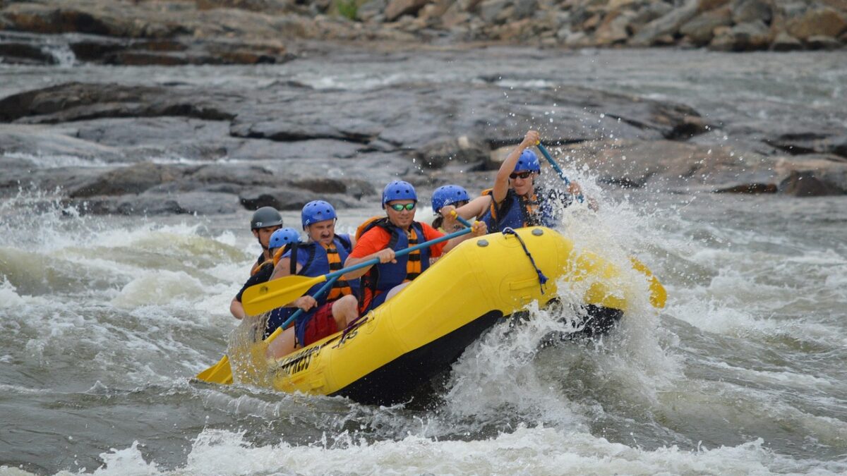 Akarsuda rafting botuyla rapidlerden geçen bir grup gezgin