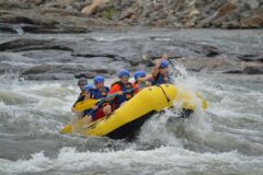 Akarsuda rafting botuyla rapidlerden geçen bir grup gezgin
