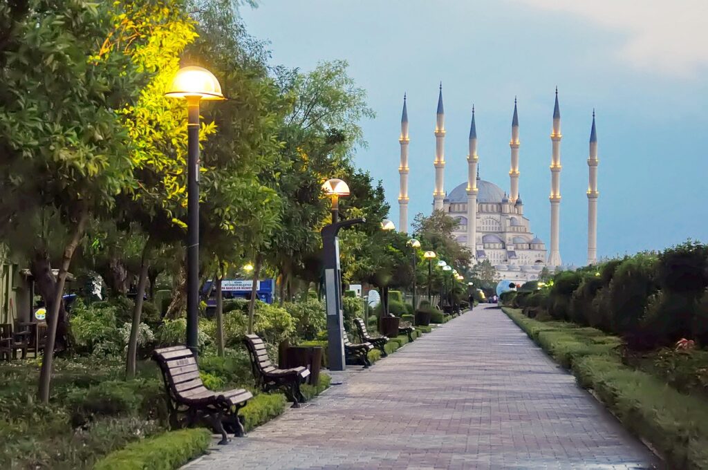 Gölgeli ağaçların altında bankların olduğu sakin bir şehir parkı