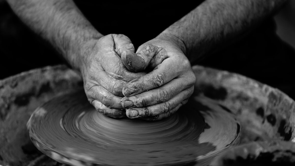 Türkiye'de geleneksel bir seramik atölyesinde çark başında çalışan usta ve çamur
