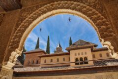 Granada'daki Alhambra sarayının günbatımında görünümü ve çevresindeki yeşil tepeler