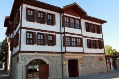Ege köyünde kireçtaşı duvarlı taş ev oteli ve çiçekli avlusu