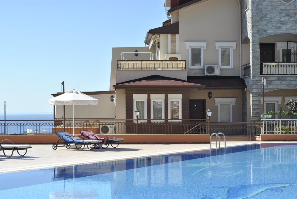 Tatil köyü otelinde havuz kenarında şezlonglar ve şemsiyeler
