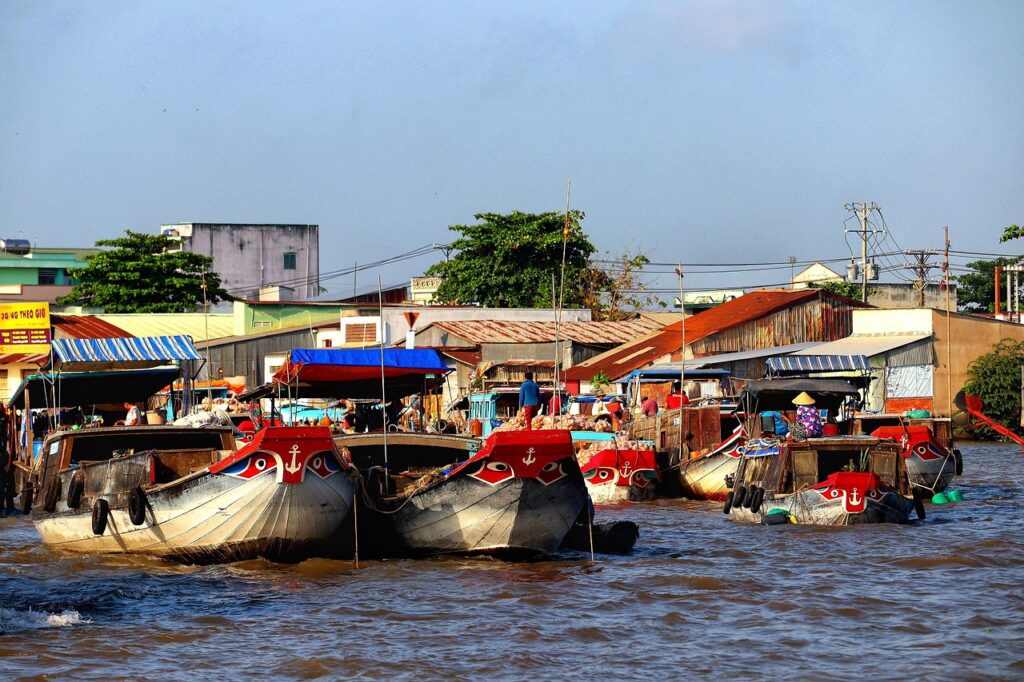 Mekong Deltası'nda kıyıdan geçen ahşap tekneler