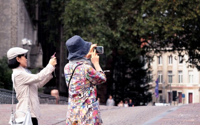 Ünlü bir turistik yerde telefonuyla fotoğraf çeken bir gezgin