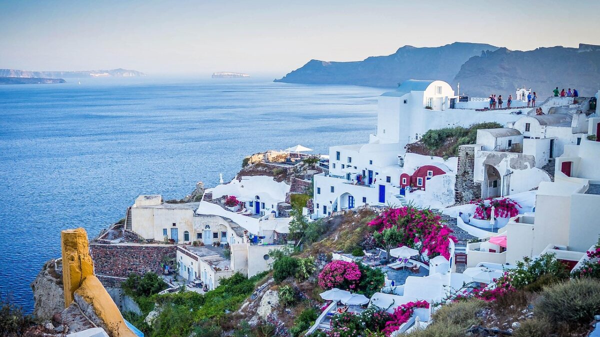Ege Denizi kıyısındaki beyaz evleri ve mavi kubbeleriyle Santorini köyü manzarası