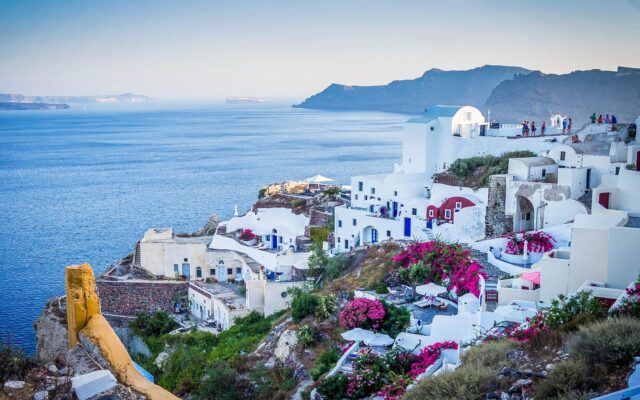 Ege Denizi kıyısındaki beyaz evleri ve mavi kubbeleriyle Santorini köyü manzarası