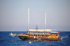 Türkiye kıyısında berrak deniz üzerinde ilerleyen geleneksel bir gulet tekne