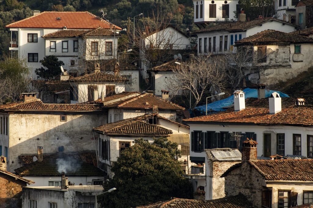 Alaçatı sokaklarında yürüyen ziyaretçiler ve taş binalar