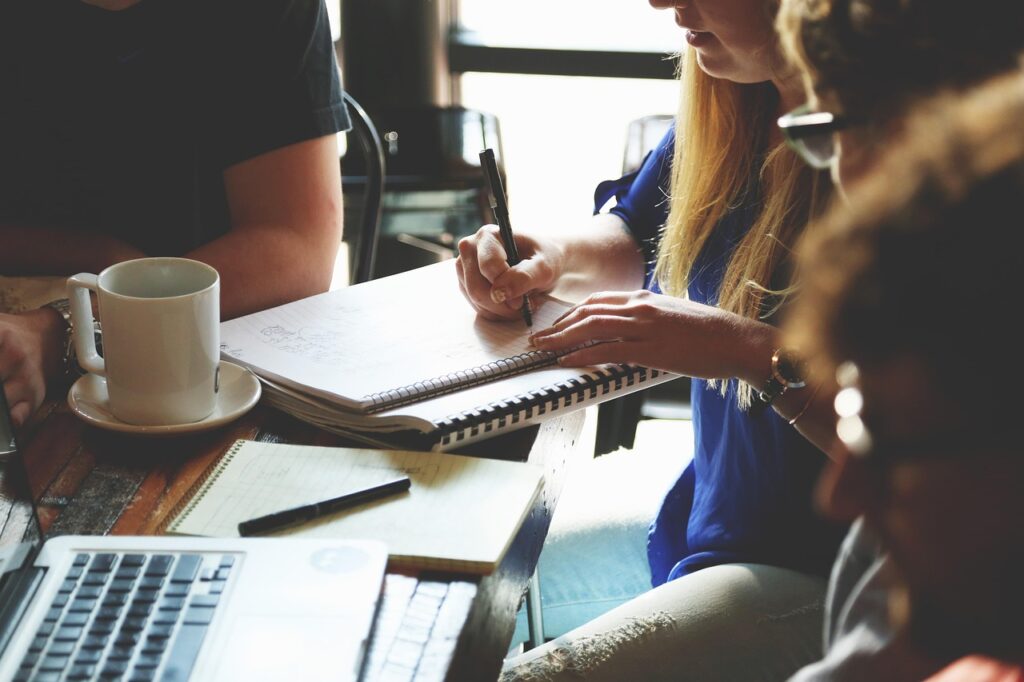 Tatil bütçesi yazılan bir defter ve kahve fincanı